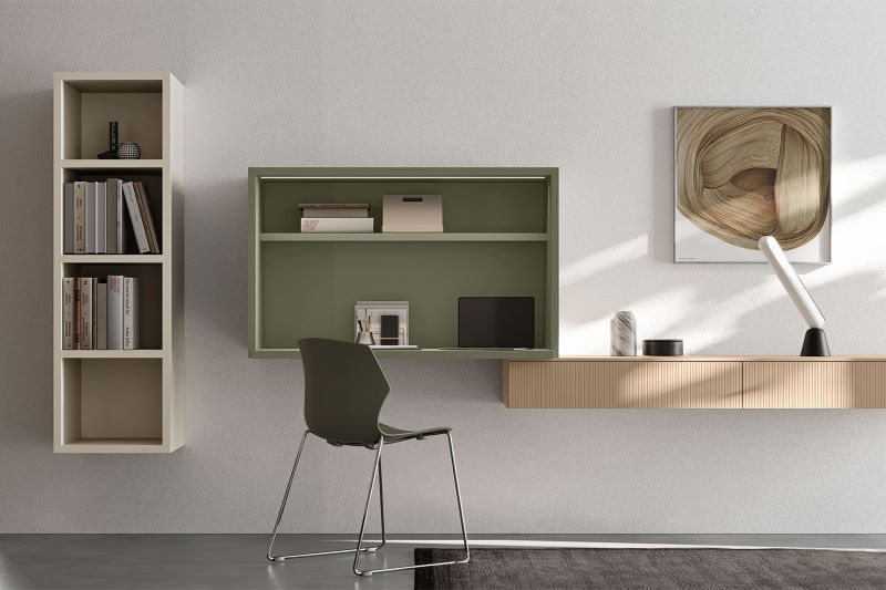 Angolo studio con scrittoio sospeso verde oliva, cassetti a parete in finitura cannettata e libreria aperta