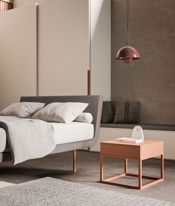 Camera con letto su piedini alti e comodino minimalista arancione