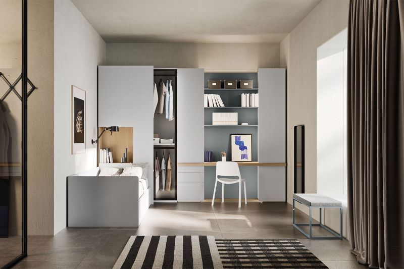 Cameretta grigia e legno chiaro con letto parallelo alla parete, guardaroba e angolo studio
